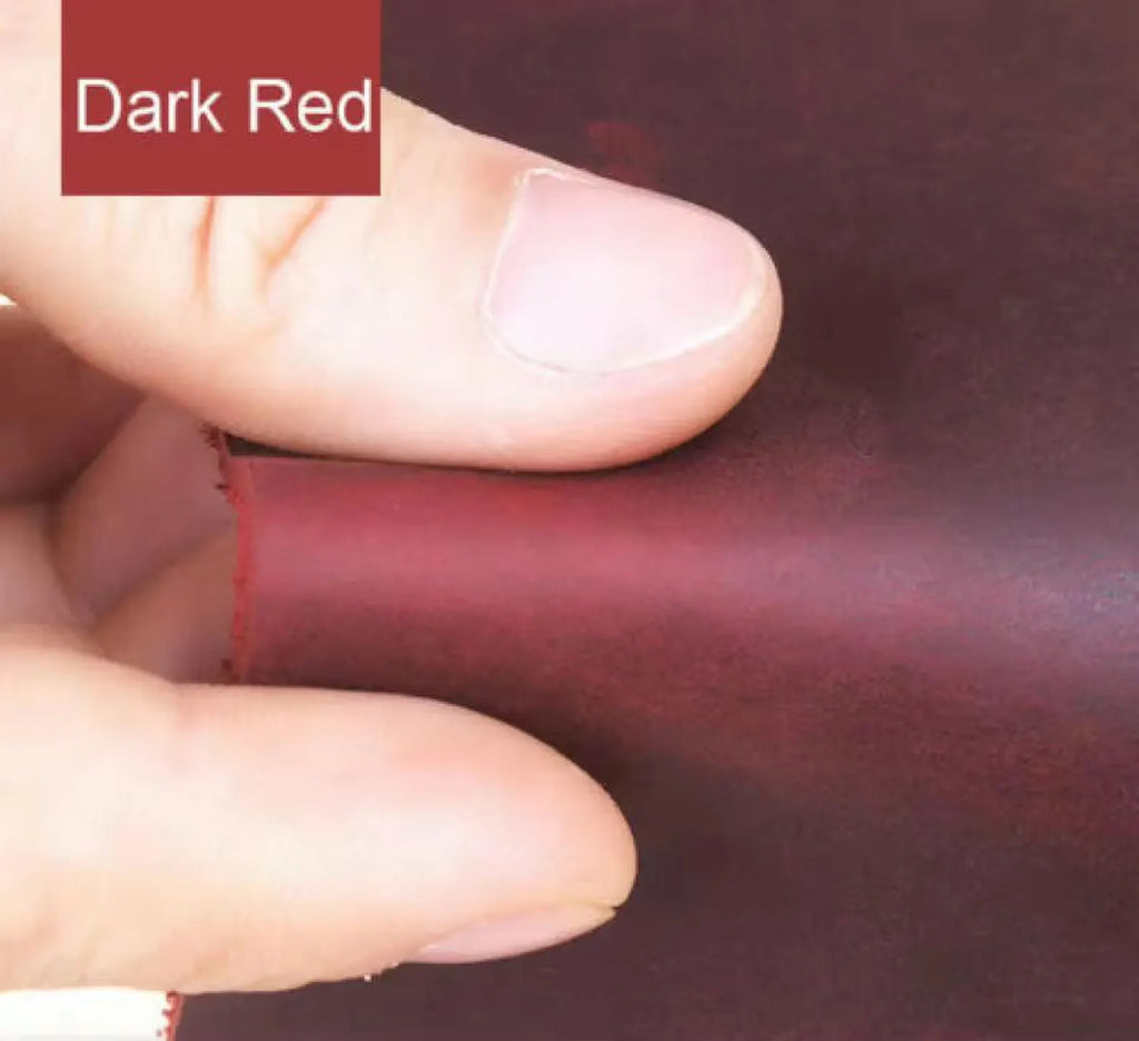 Dark red leather with a hand holding it, showing texture and color.