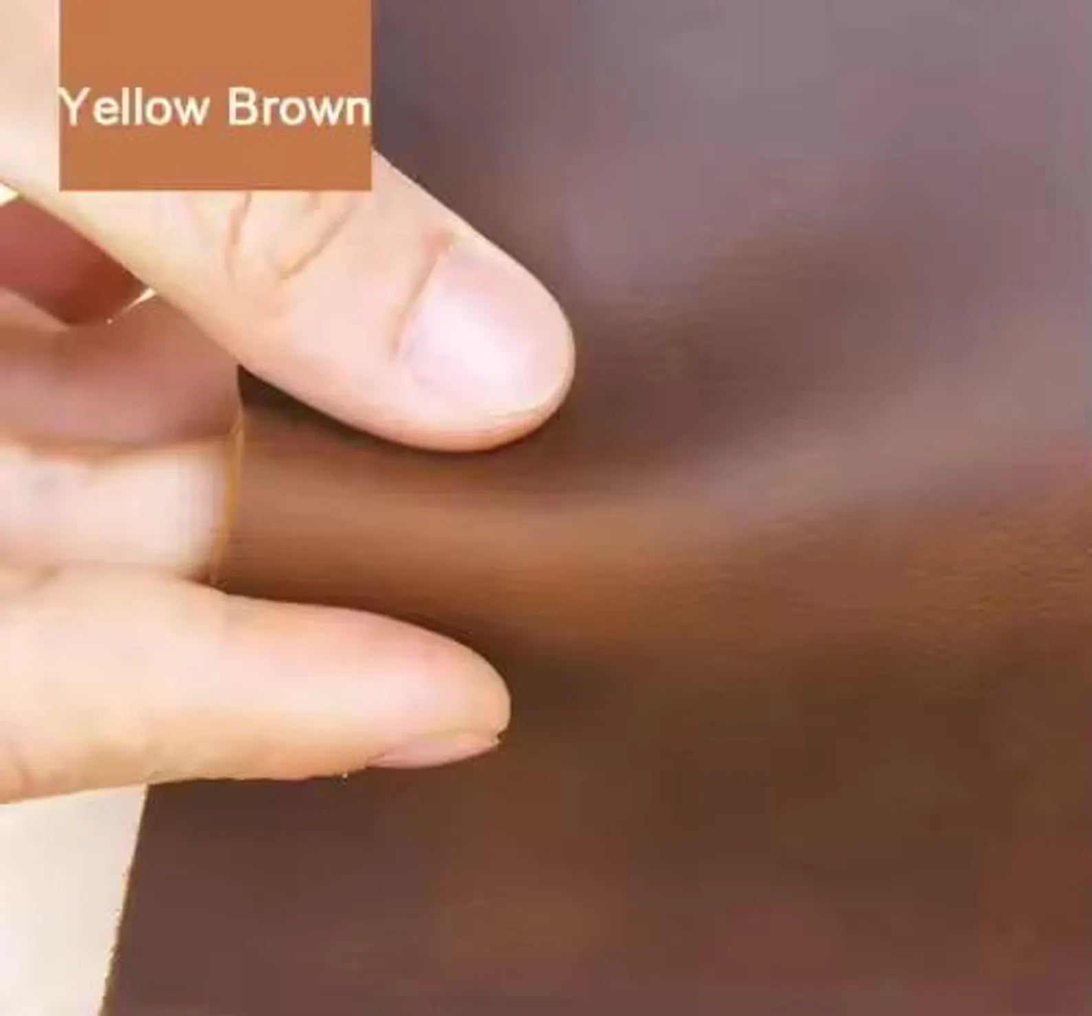Hand holding a swatch of yellow brown color