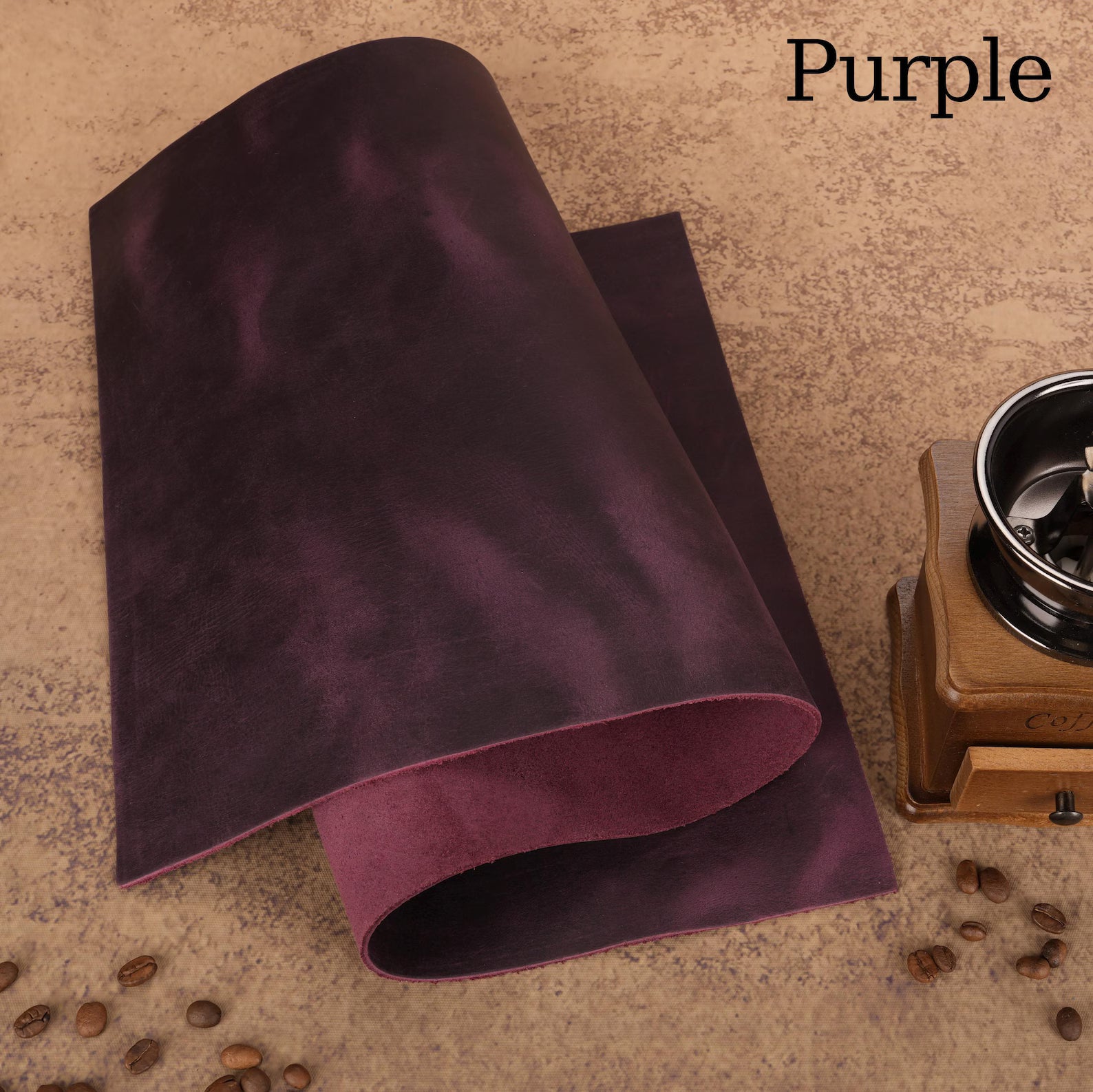 Purple Leather roll on a textured surface with coffee beans and a grinder.